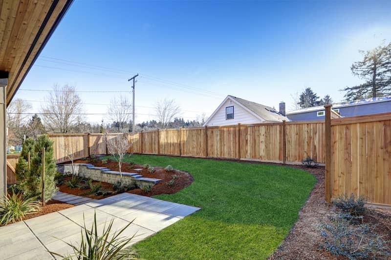 Sloped backyard surrounded by wooden fence