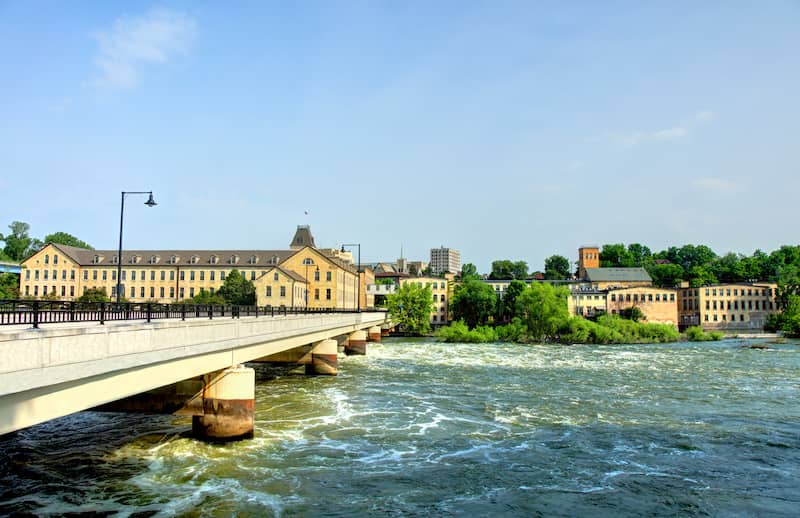 View of Appleton buildings, rushing river and concrete bridge.