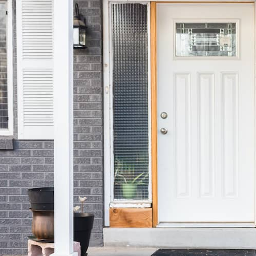 A turquoise bicycle on a front porch, adding a decorative element to the entrance of a home.