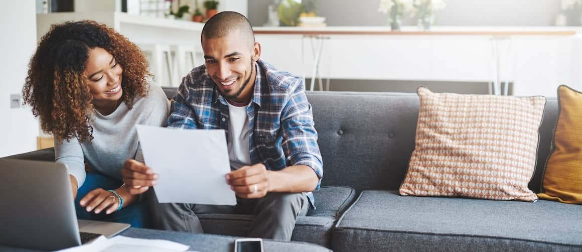 Couple reading approval for loan and smiling.