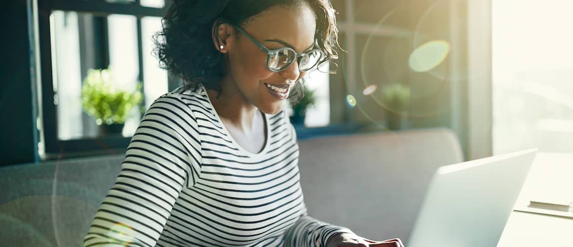 Young African woman smiling and working online with a laptop