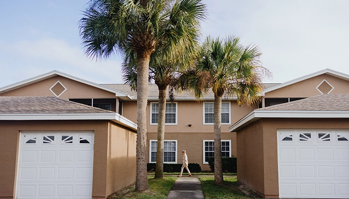 Tan home with palm trees.