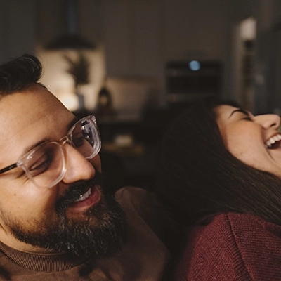 Man smiling holding woman who is laughing.