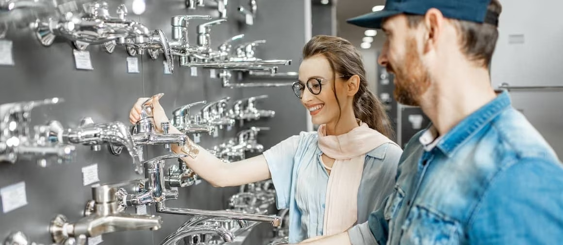 Woman choosing new faucet at store.