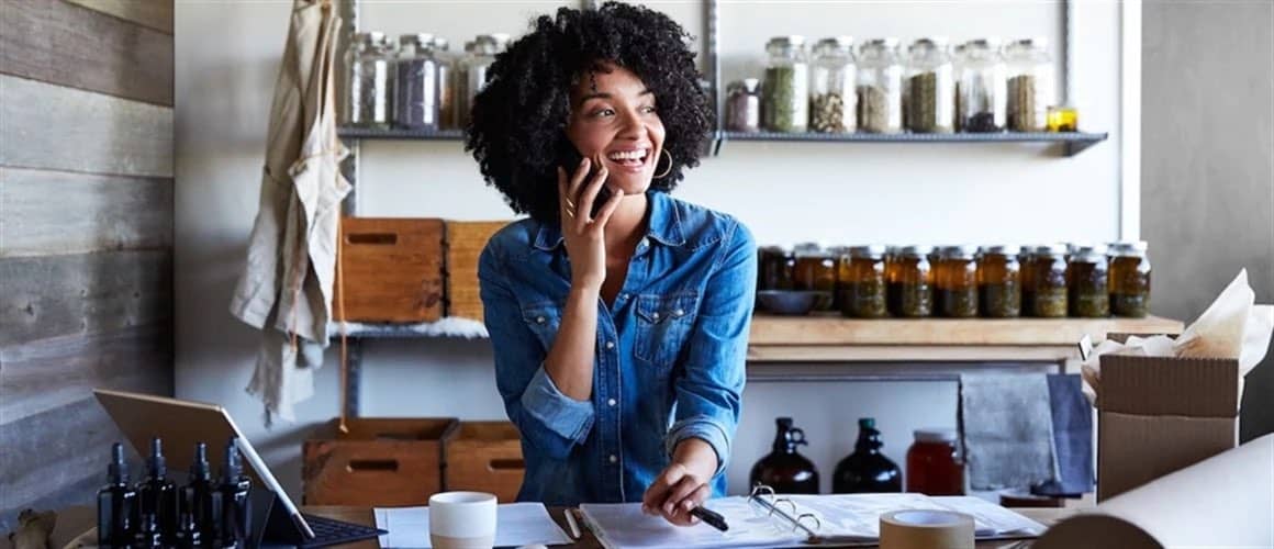 Image of woman sitting at workspace, organizing finances.