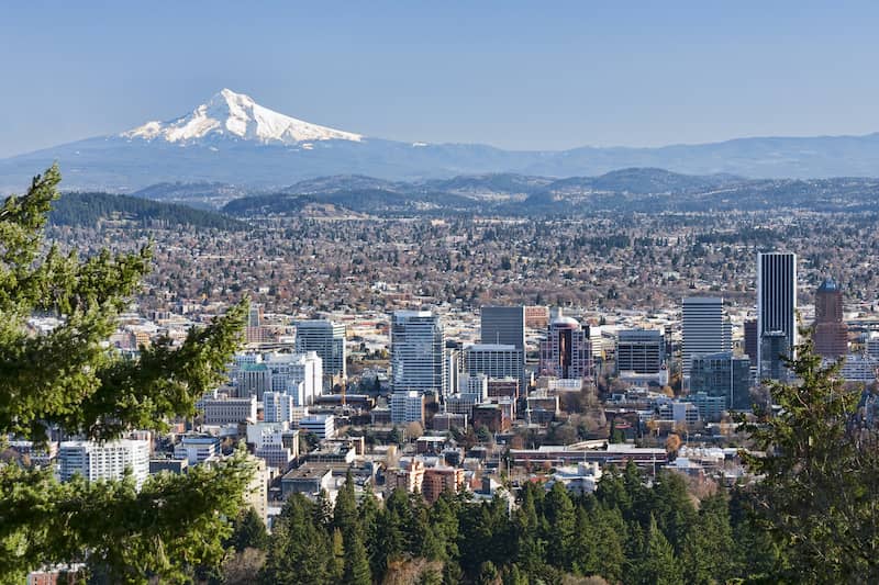 RHB Assets From IGX: The picturesque Portland, Oregon skyline with a river and lush greenery.