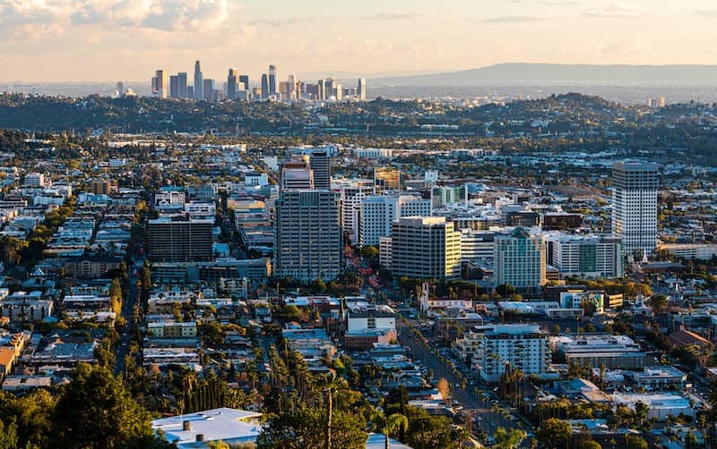 Distant, aerial view of Glendale, California, with skyscrapers in the distant background along with some mountains.