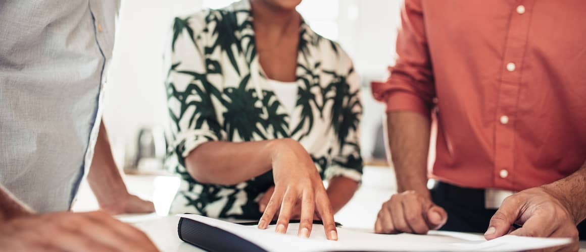 Close up of clients and Realtor reviewing contract.