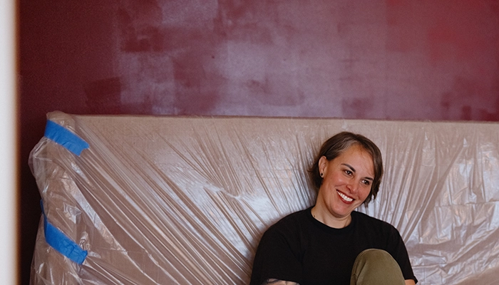 Couple laughing and on bed with plastic covering.