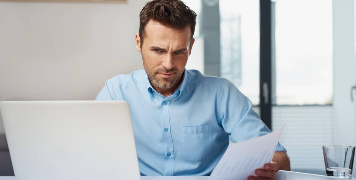 A man working on paperwork, potentially related to mortgage documents or financial planning.