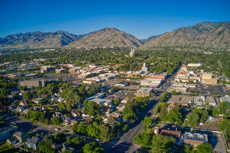 Aerial view of the city of Logan in Utah with large mountains.