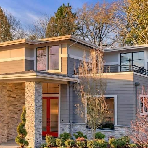 A modern contemporary house with lots of windows, showcasing architectural design and residential style.