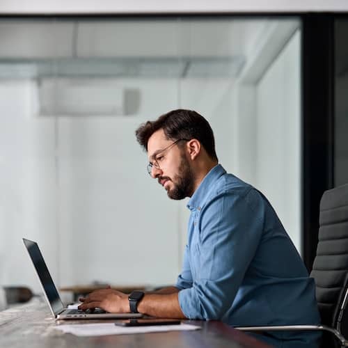 Man on laptop with a serious face.