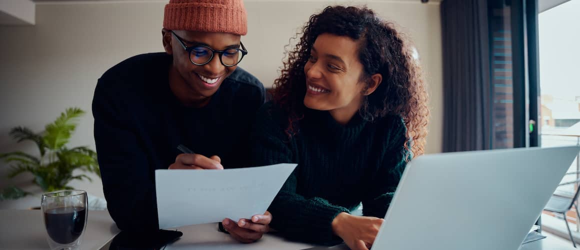 A young african-american couple happily doing paperwork for their new home.