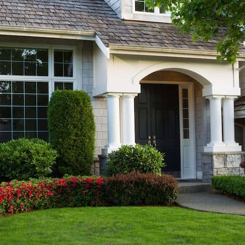 A beautiful house with a green front yard.