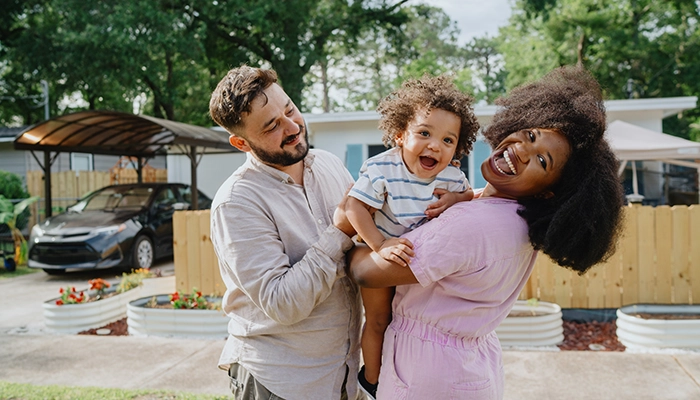 Man and woman holding laughing baby.