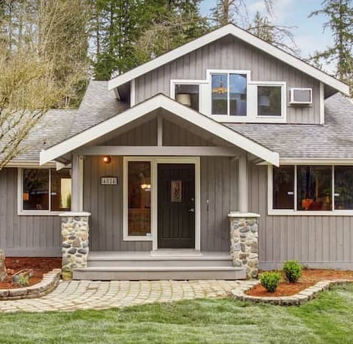 Grey home with white framing and red mulch, depicting a specific house exterior with landscaping.