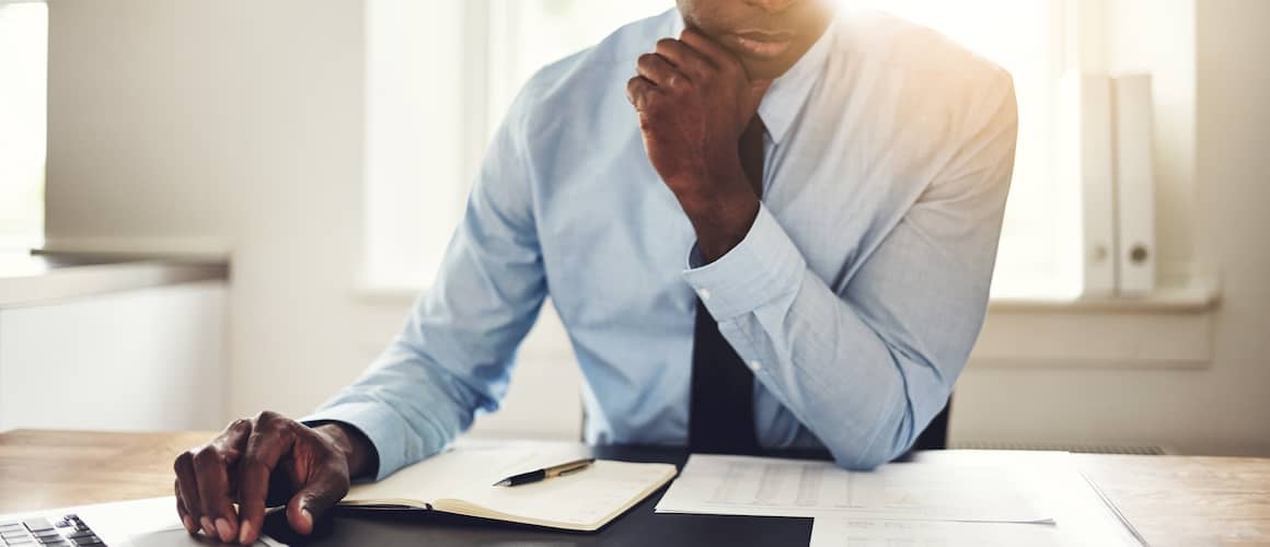 A man carefully reviewing documents related to real estate or financial matters.