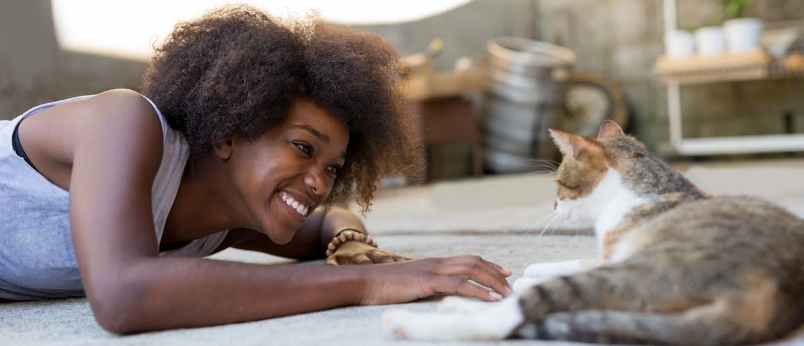 Young woman relaxing with her cat at home.