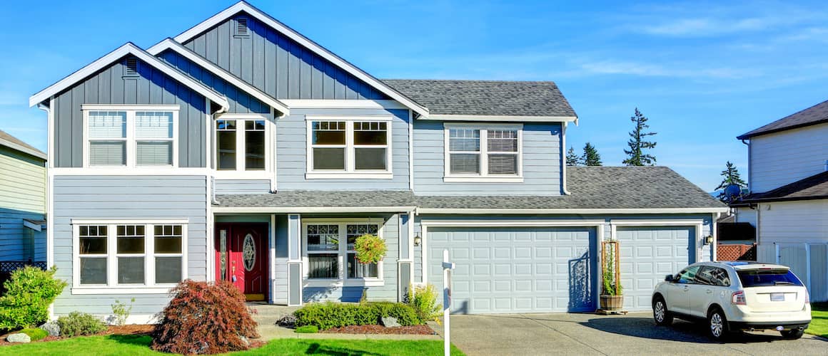 Large two-story house with a garage and car parked on driveway.