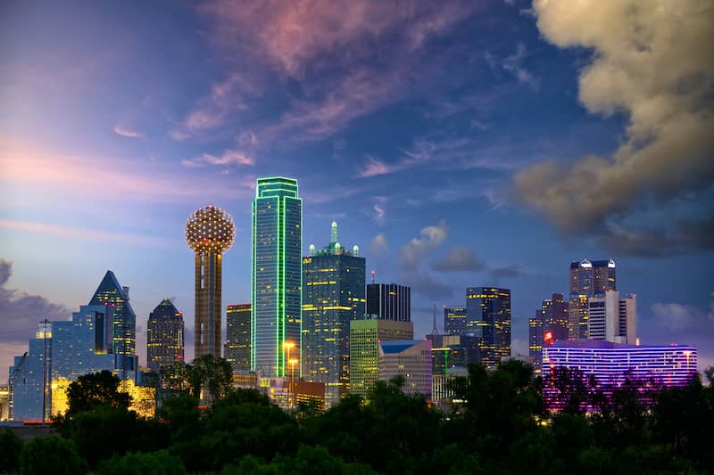 RHB Assets From IGX: Dallas city skyline at dusk with a vibrant purple and orange sky