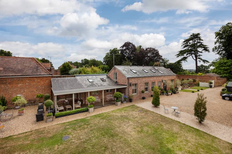 Aerial view of a brick horse barn converted into condos.