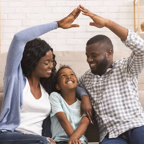 A young family creating a symbolic roof over their daughter's head, possibly representing homeownership aspirations or planning.
