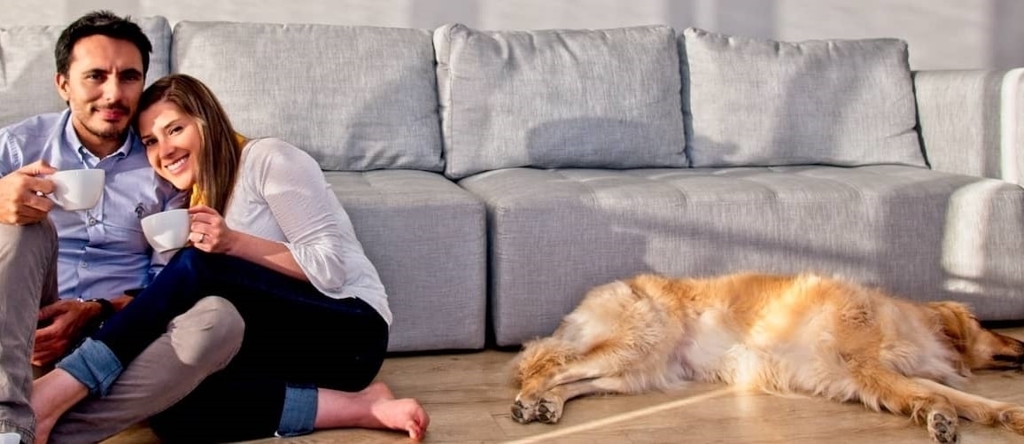 A couple sitting in the living room with their pet dog.