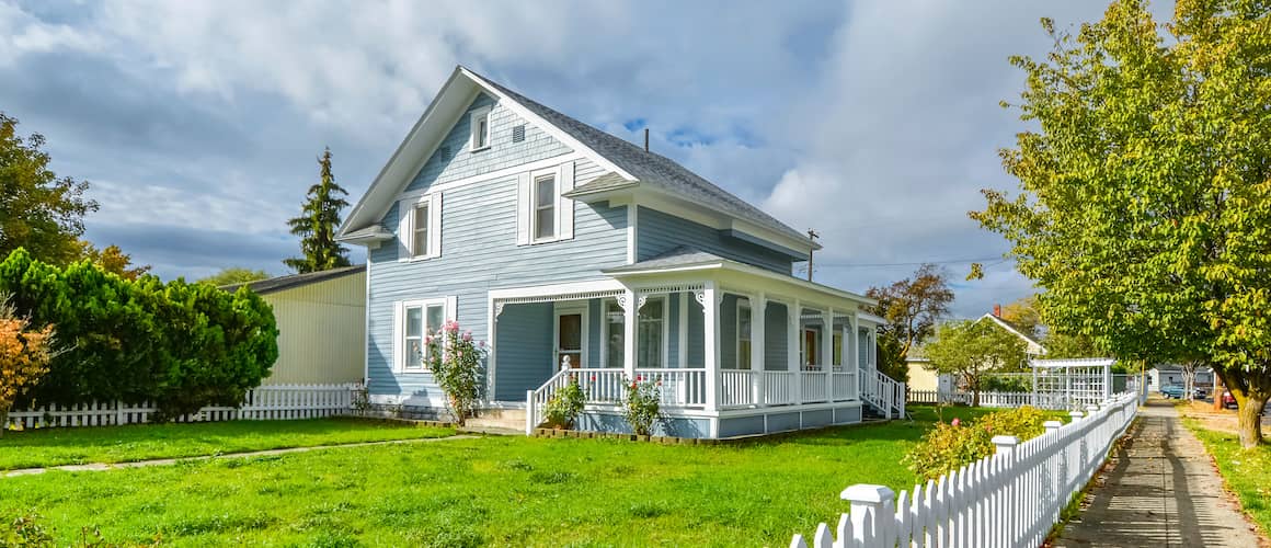 A Victorian cottage with a white picket fence, showcasing a charming and picturesque residential setting.