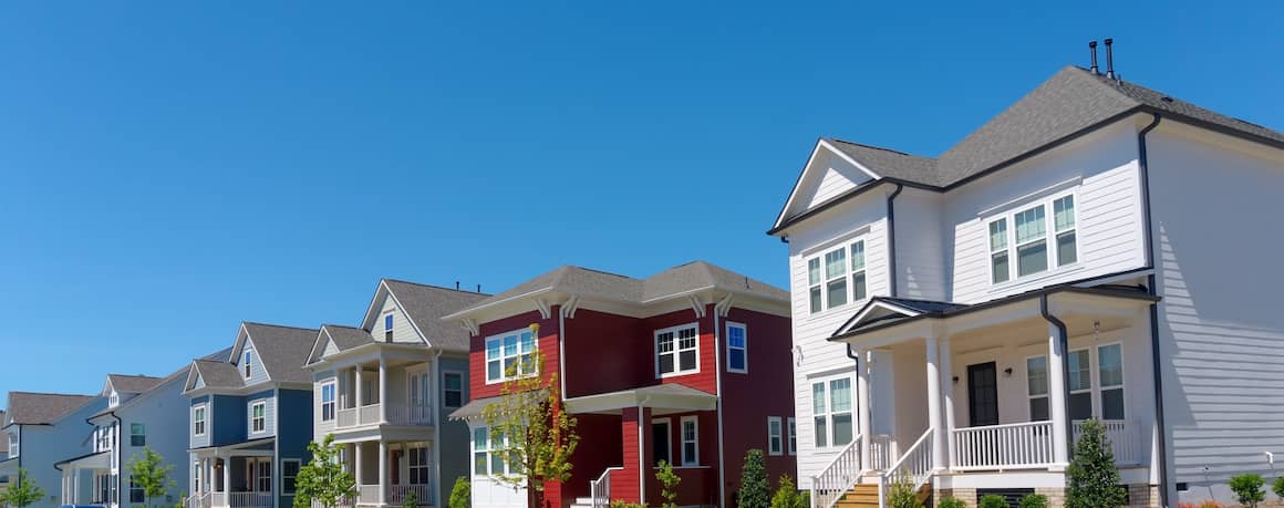 RHB Assets From IGX: Row of suburban homes with manicured lawns and trees.