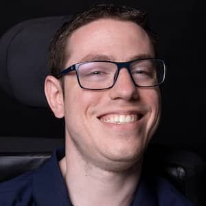 Headshot of a man with glasses smiling.