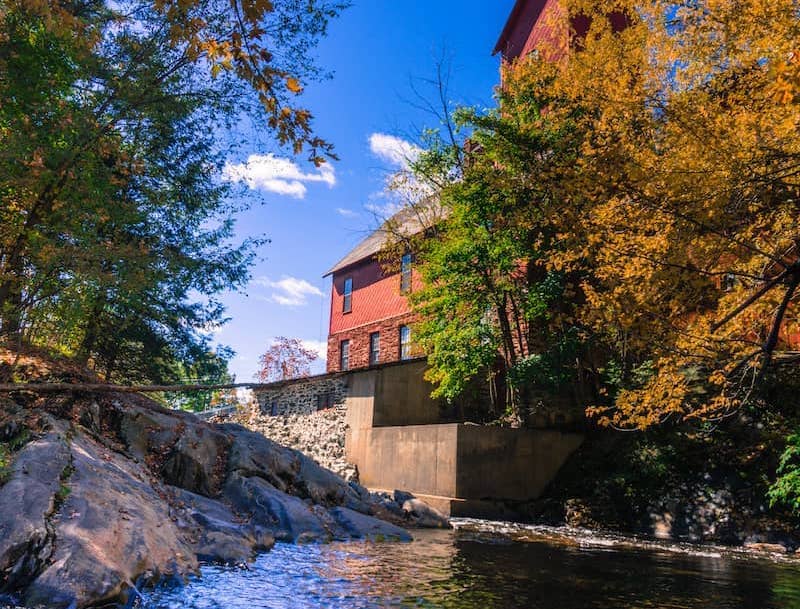 RHB Assets From IGX: Historic mill in Jericho, Vermont, surrounded by lush greenery.