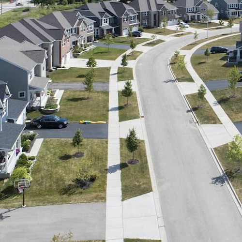 A street in a suburb lined with identical homes.