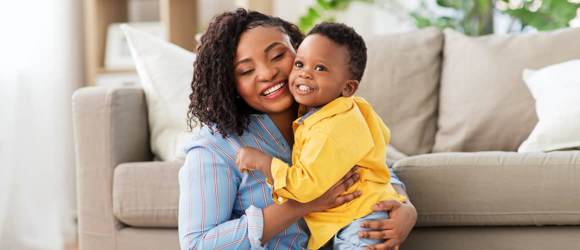 Stock-Black-Mother-Embracing-Her-Young-Son-In-A-Yellow-Coat-AdobeStock264301201 copy.jpg