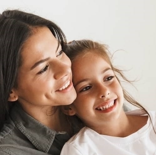 Mother and daugher smiling and snuggling.