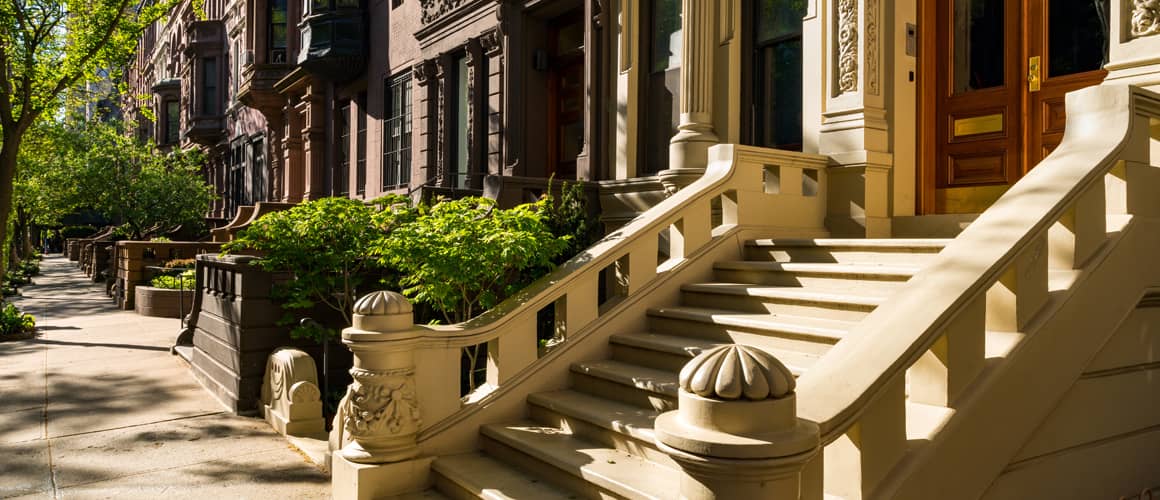 Brownstone townhouses in NYC' - A row of historic, elegant homes in the heart of the city.