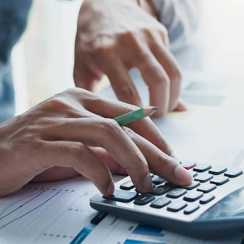 Hands calculating, potentially symbolizing financial calculations or planning related to real estate or mortgage.
