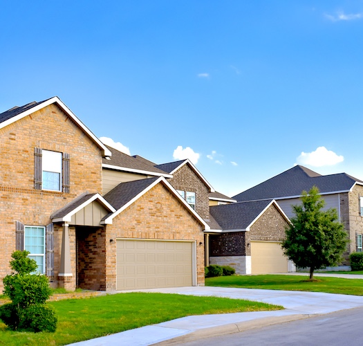A couple of new construction homes along a suburban street.