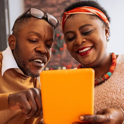 A man and women discussing something on a tab.