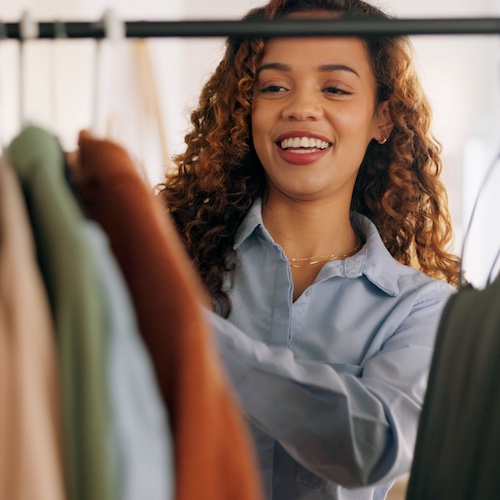 Woman looking through a clothes rack.