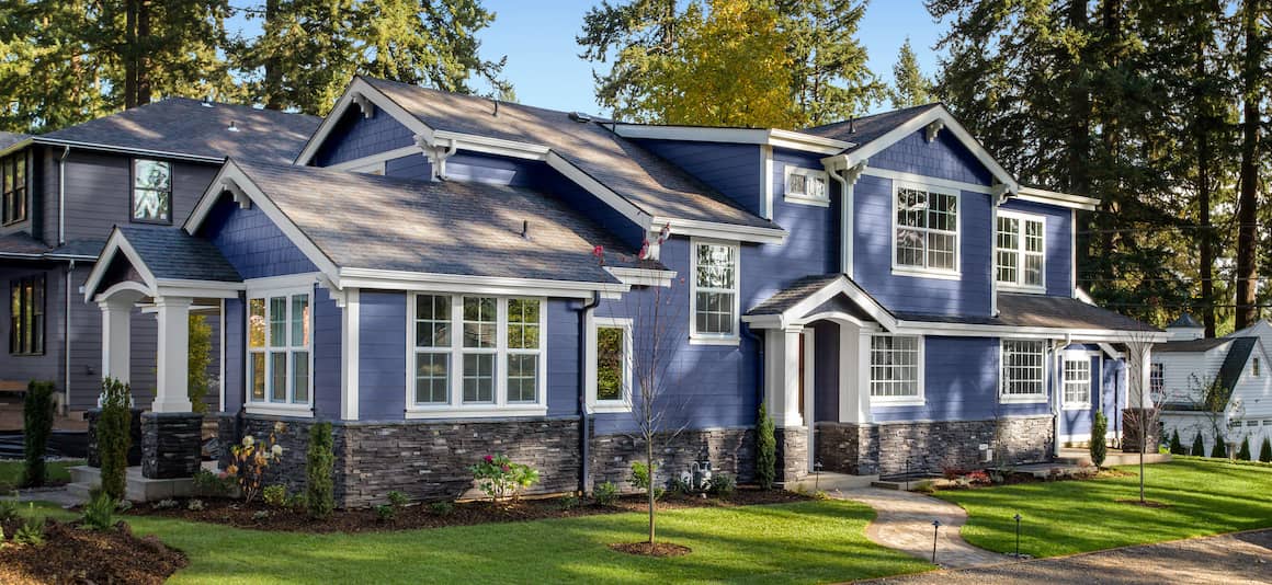 A real estate agent assisting a couple in front of a house.