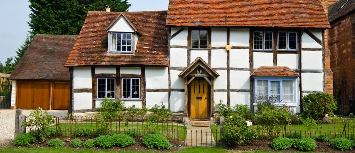 English cottage with hedges and fencing.