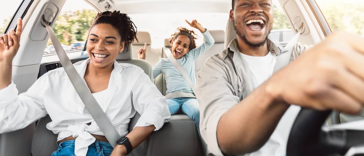 Happy family driving in car.