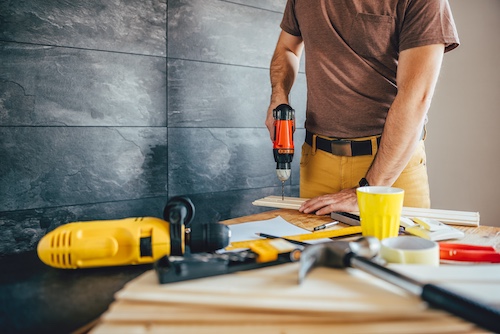 Man using power drill working on home improvement project.