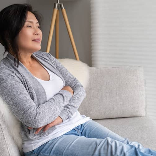 A woman relaxing at home, suggesting a comfortable and serene atmosphere in a residential setting.
