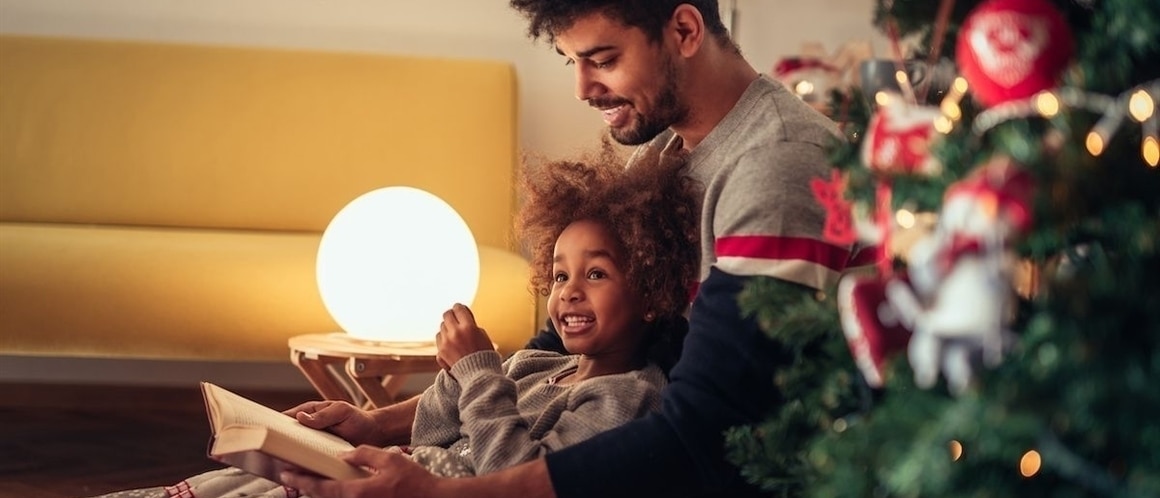 RHB Assets From IGX: Father and daughter relaxing together on a couch in a bright, cozy living room.