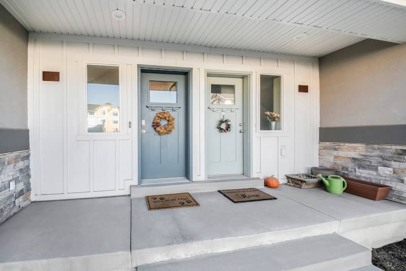 Exterior view of a multifamily style home porch with two entrance doors.