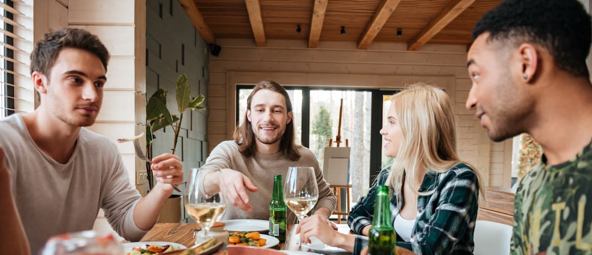 People of different races enjoying dinner on the dining table.