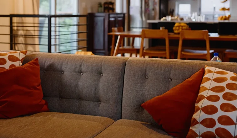 Living room with a sofa and open view into a dining area.