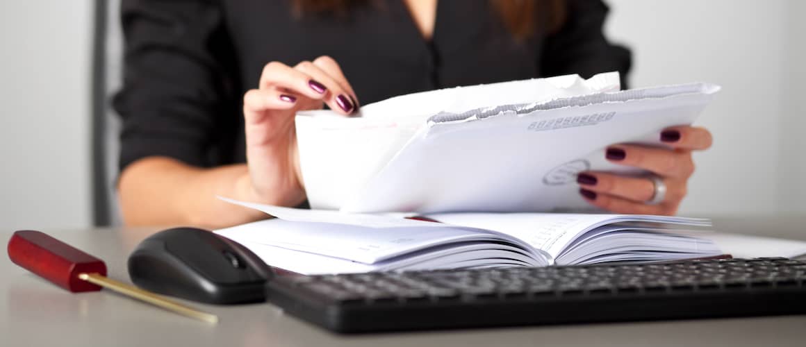 Woman sorting letters at a desk.